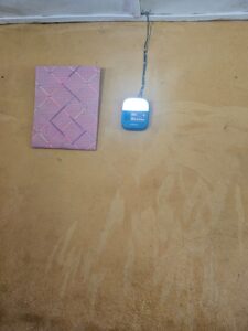 Purple painting next to a light on a yellow wall